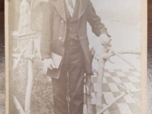 2.5″ x 4″ — Small Cabinet Card of a Man Standing by a Bed — H. Krause’s Photographic Studio, La Cour Street (Near Post Office) Pioche, Nev
