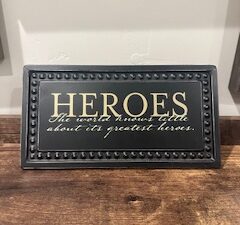 Sign ~ “Heroes, The world knows little about its greatest heroes.” (10 in x 5.25 in)