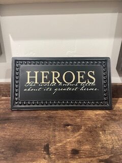 Sign ~ “Heroes, The world knows little about its greatest heroes.” (10 in x 5.25 in)