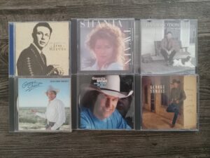 6 Misc. Music CDs with Music by Artists Like Jim Reeves, Shania Twain, Daniel O’Donnell, and George Strait